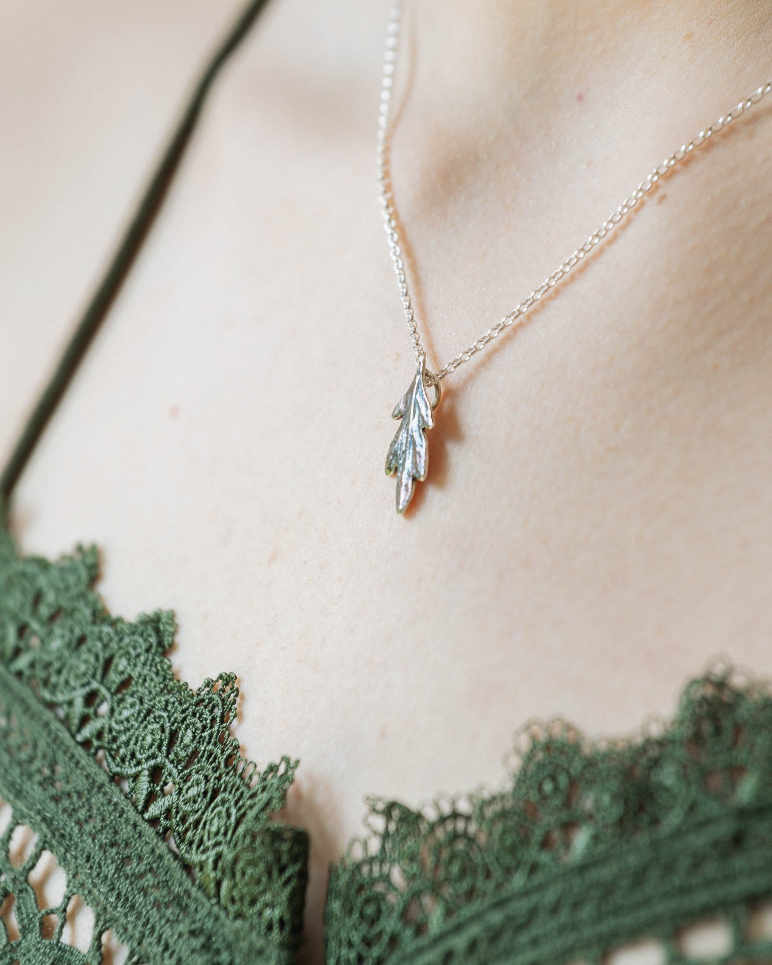 A small silver leaf pendant with colourful patina