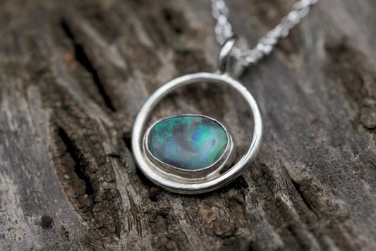 a colourful australian opal pendant in a silver ring