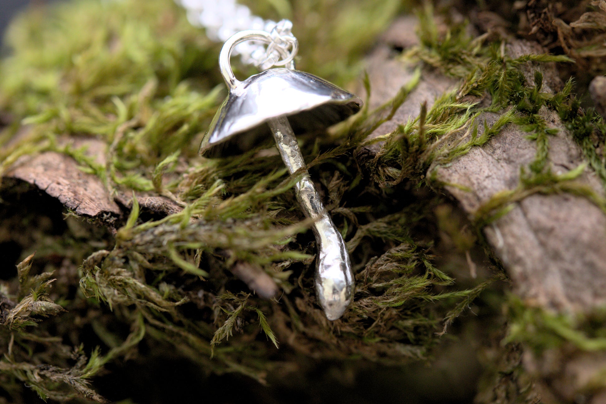 A handcrafted silver fungi pendant