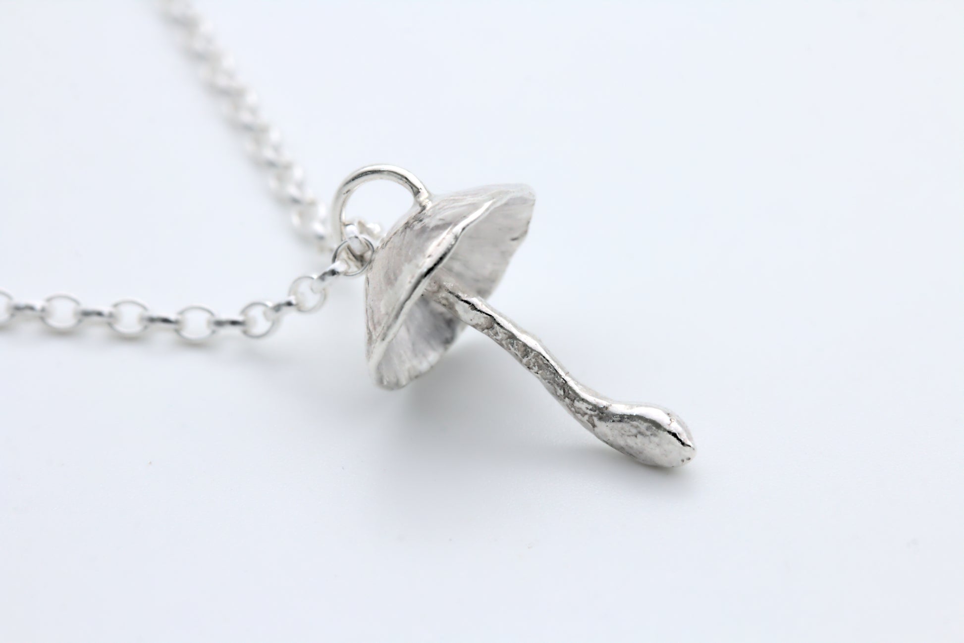 A handcrafted silver fungi pendant