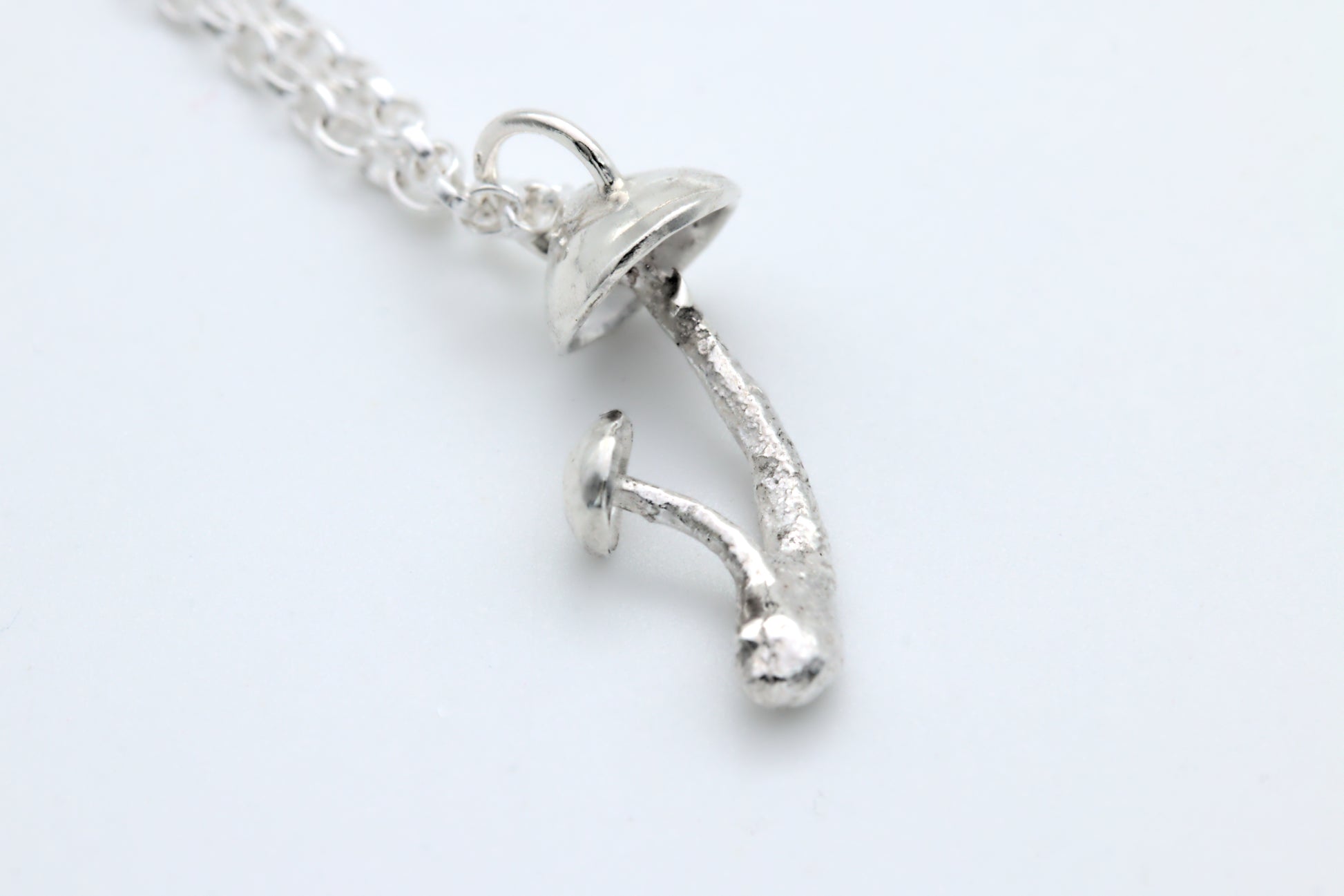 A handcrafted silver fungi pendant