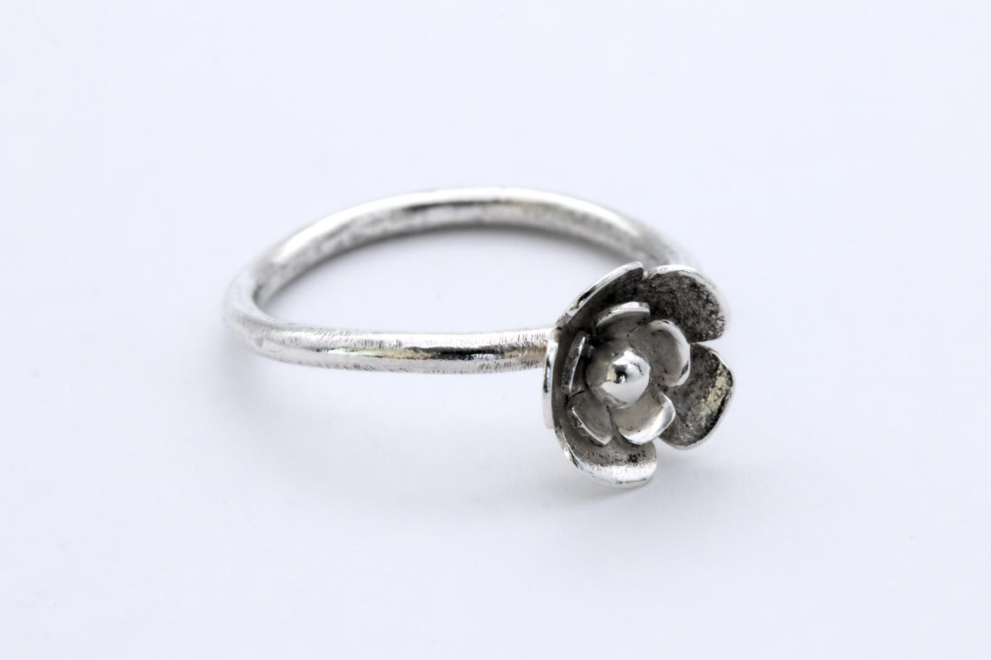 A silver ring with a 3-tier flower