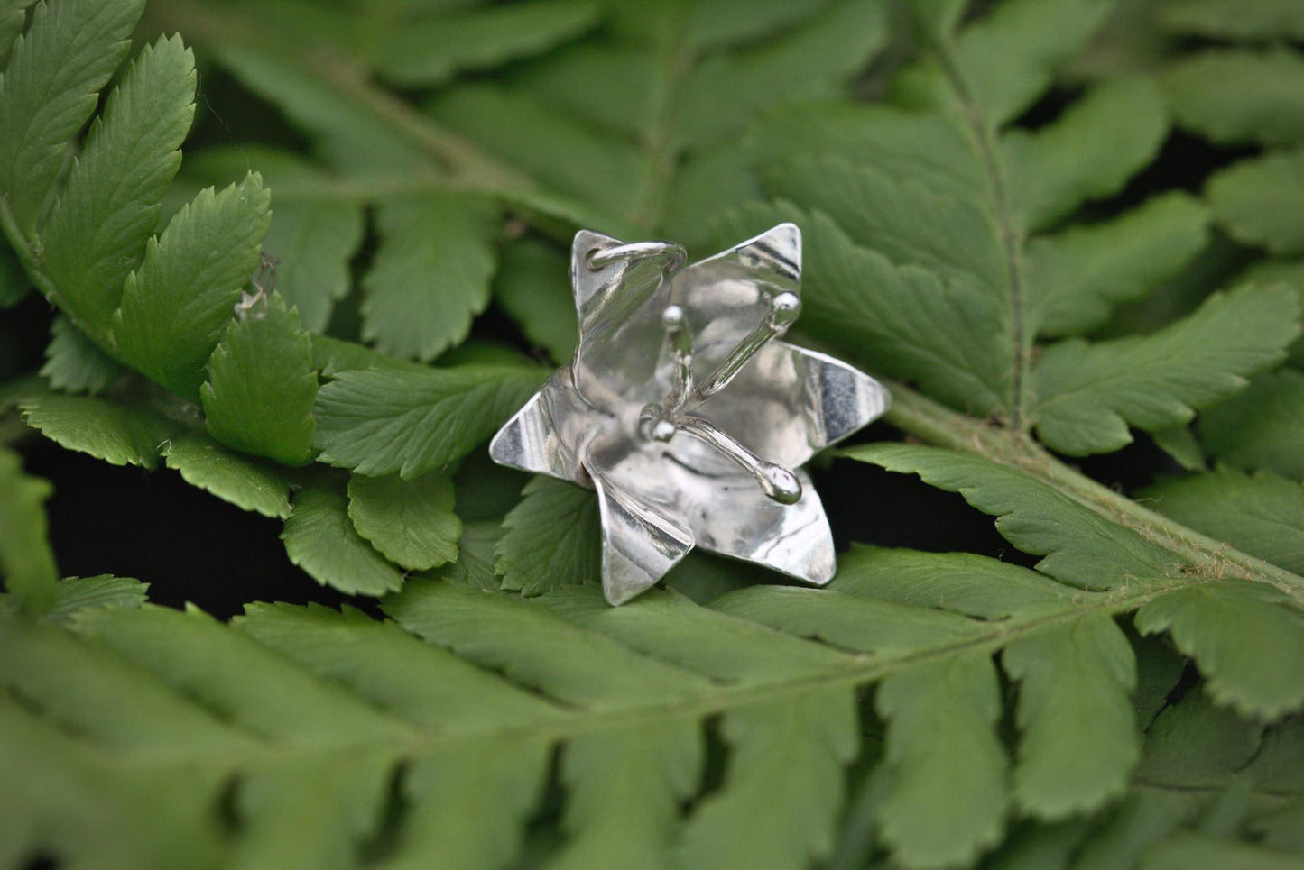 a small lily flower pendant in silver