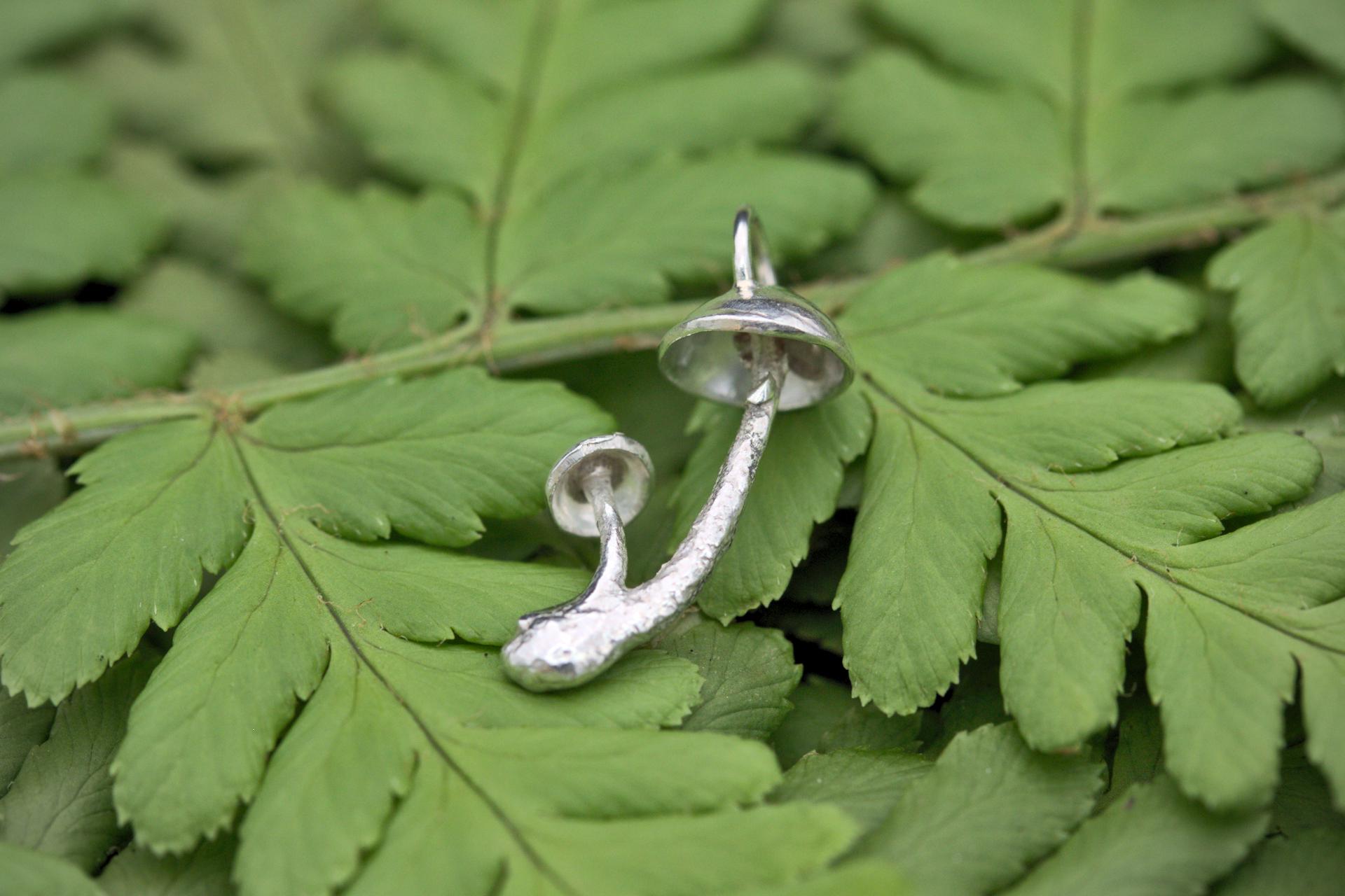 A handcrafted silver fungi pendant