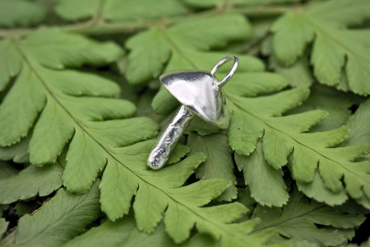 A handcrafted silver fungi pendant