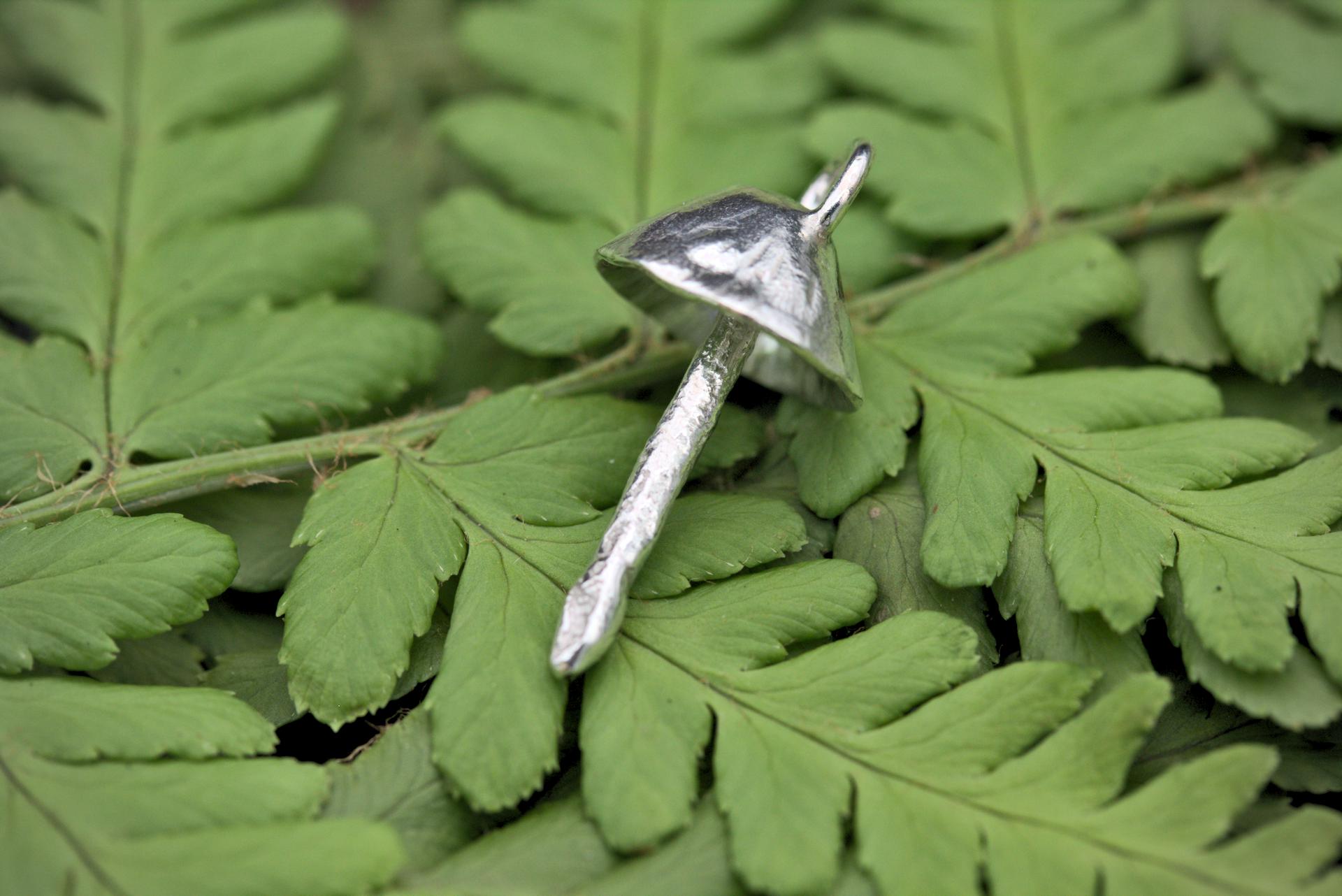 A handcrafted silver fungi pendant